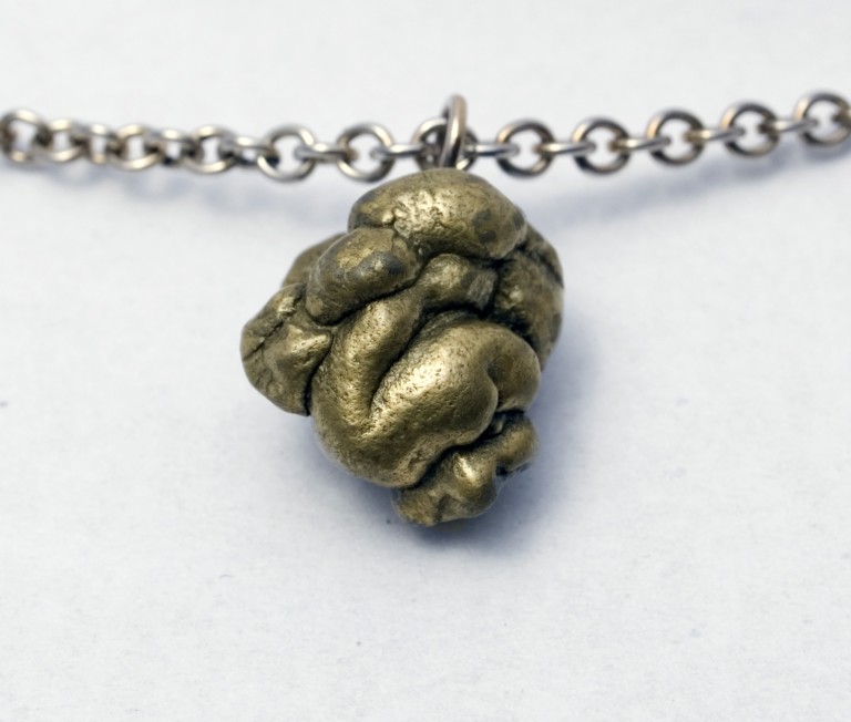 Very poo-like golden pyrite rock on a bronze chain.