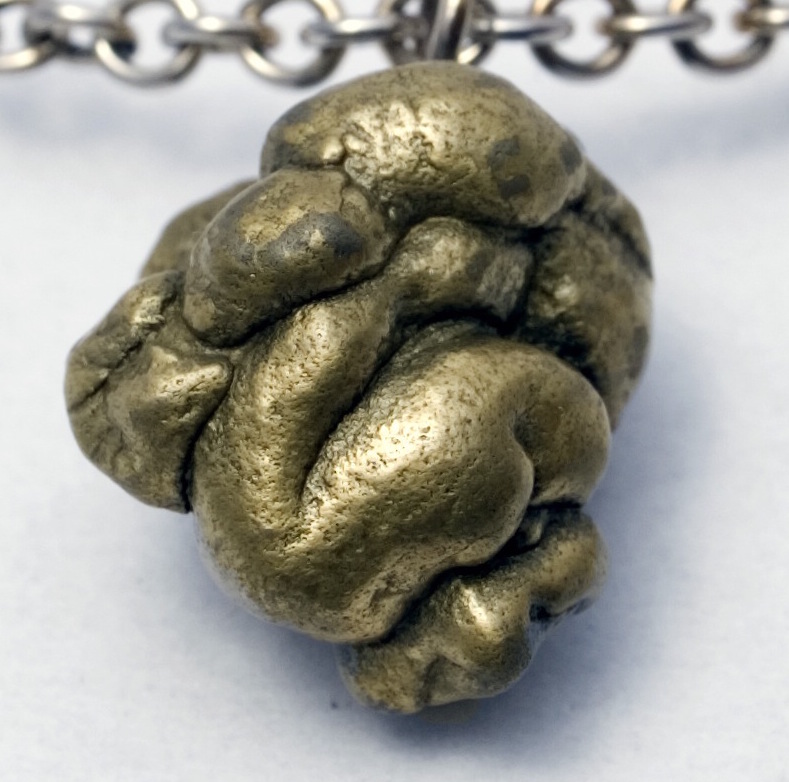 Very poo-like golden pyrite rock on a bronze chain.
