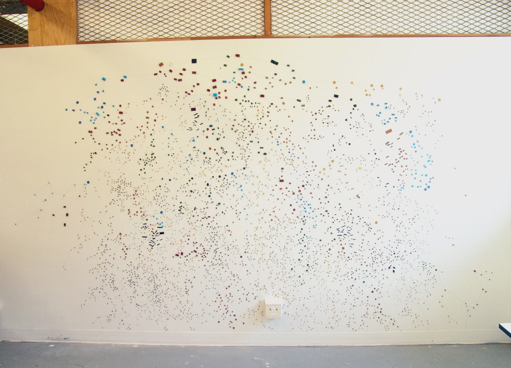 10 foot stretch of white wall covered in tiny multicoloured dots connected by lines.