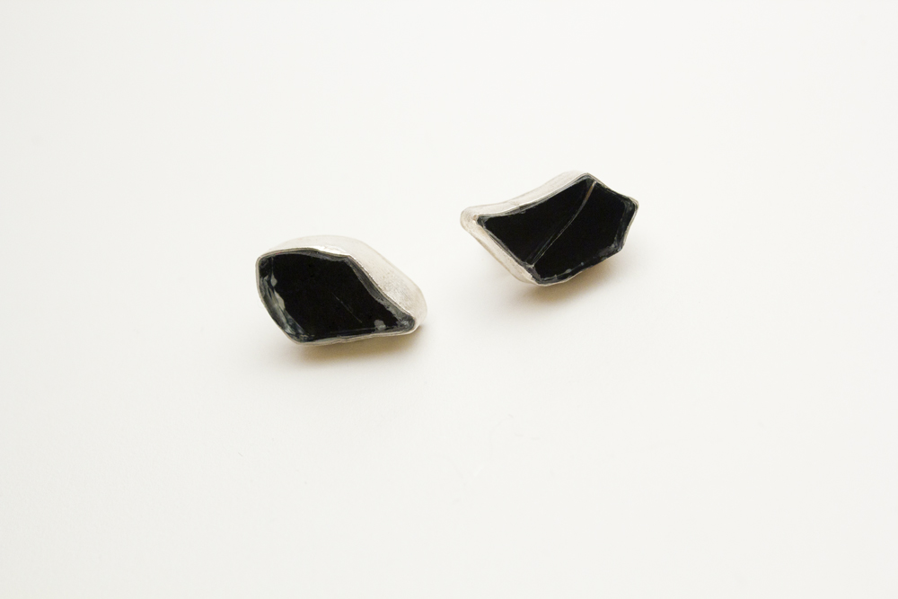 A pair of sterling silver stud earrings set with tinted broken car glass in sterling bezels.