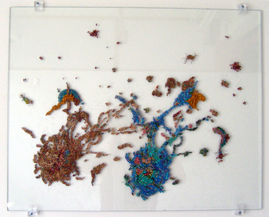 Straight on look at a glass panel on the wall covered in electronics components (resistors) in blues and reds. Resistors create an image of 2 macrophages destroying cells.