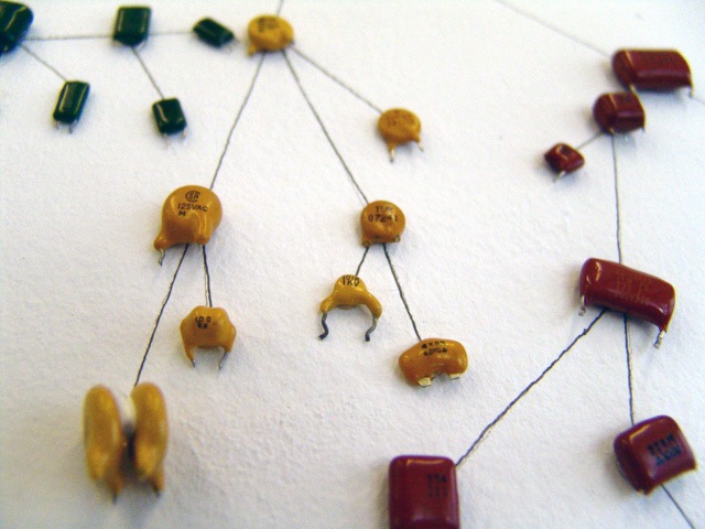 Close up of some of the capacitor 'creatures' focused on some yellow ones of different shapes, 2 are stuck together and end their evolutionary line.